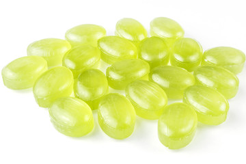 Mint oval lollipops of fresh green color with a blueprint on a white background. Sweets, dragee, food macro.