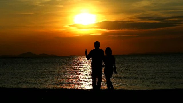 Couple lover taking selfies and hugged while sunset on the sea