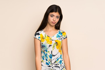 Teenager girl with floral dress with sad and depressed expression
