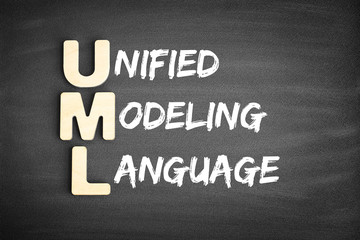 Wooden alphabets building the word UML - Unified Modeling Language acronym on blackboard