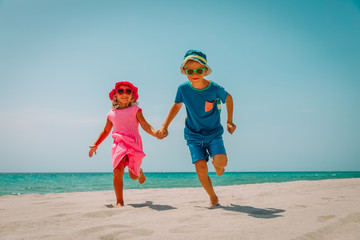 Fototapeta na wymiar happy cute boy and girl run on beach