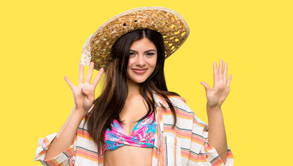 Teenager girl on summer vacation counting nine with fingers over isolated yellow background