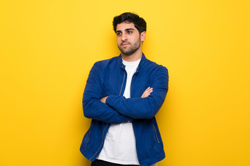 Fototapeta premium Man with blue jacket over yellow wall portrait
