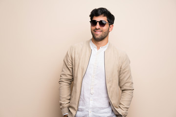 Fototapeta premium Young man over isolated wall with glasses and happy