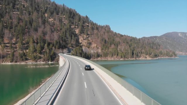 Bridge at Silvensteinsee Munich Germany. Drone photage with DJI Mavic Air following cars for a cinematic mood. Made on april 2019 it contains Ice in one side of the bridge.