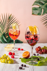 Cold sangria in wine glasses on wooden table in morning sunlight