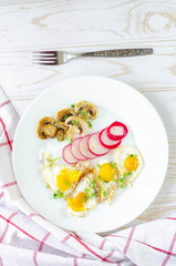 Healthy breakfast with quail eggs, radish, mushrooms and microgreens. Diet on a plate