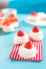 Beautiful pavlova cakes with strawberries on a blue background. Selective focus. Tasty sweet breackfast. Wedding morning. Meringue with cream.