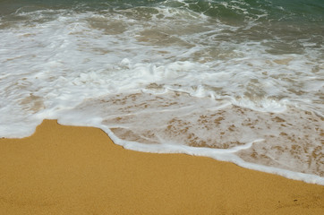 Fototapeta na wymiar Paradise beach, golden sand, waves and sea foam