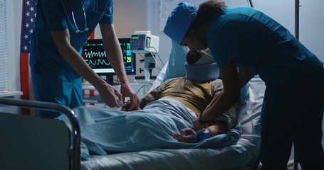 Injured soldier lying in hospital among doctors