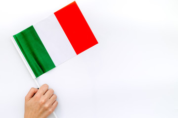 Independence Day of Italy concept with flag in hand on white background top view