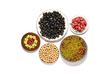 Dry peanuts and variety of beans in plate isolated on white background