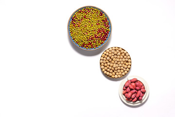 Dry peanuts and variety of beans in plate isolated on white background