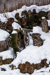 Alte mit Wasser betriebene Mühle, die bemoost ist und mit Schnee bedeckt.