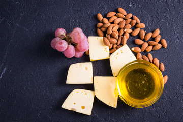 Snacks with wine - various types of cheeses, figs, nuts, honey, grapes