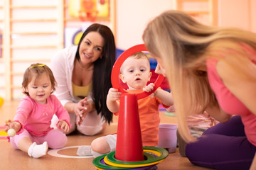 Obraz na płótnie Canvas Nursery babies group have a fun in kindergarten gym