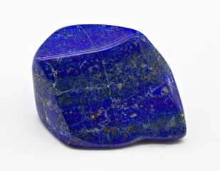 Blue polished shiny lapis lazuli stone mineral specimen with golden inclusions isolated on white limbo background