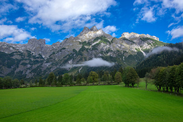 Fototapeta na wymiar Austrian Verfenveg village Alps mountains autumnal scenery with fog, green meadows and rocks