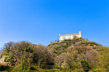 Fototapeta na wymiar The castle of Montalto Dora, at an altitude of 405 meters, on the Pistono Lake, in the morainic amphitheater of Ivrea, dating back to the mid-12th century. Clear sunny spring morning