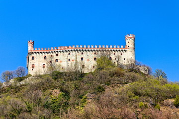 Fototapeta premium The castle of Montalto Dora, at an altitude of 405 meters, on the Pistono Lake, in the morainic amphitheater of Ivrea, dating back to the mid-12th century. Clear sunny spring morning