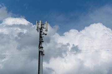 Cell phone tower with cloudy sky in background