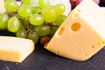 Snacks with wine - various types of cheeses, figs, nuts, honey, grapes