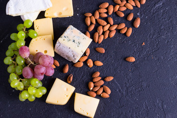 Snacks with wine - various types of cheeses, figs, nuts, honey, grapes