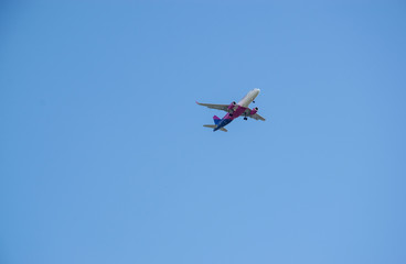 Fototapeta na wymiar View from below of an airplane flying high in blue sky