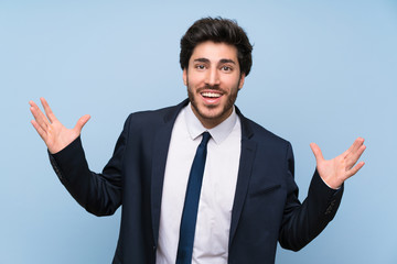Businessman over isolated blue wall smiling a lot