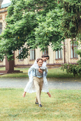 newlyweds running along the road in the park holding hands