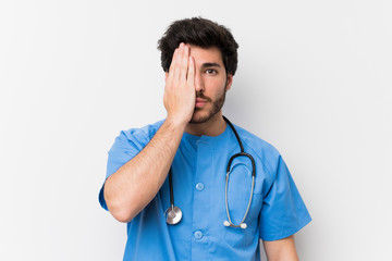 Surgeon doctor man over isolated white wall covering a eye by hand