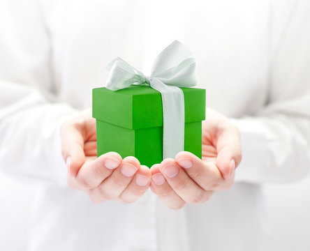 Small green present box in hands 