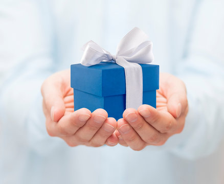 Small blue present box in hands 