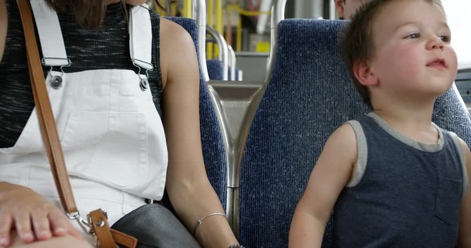 Toddler boy gets exicted as he looks out public transportation bus window