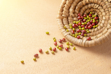 Red and green dried beans spilling out of bamboo basket