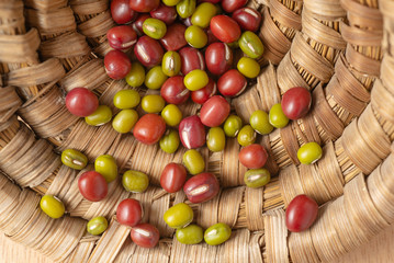 Red and green dried beans dispersing on bamboo basket texture