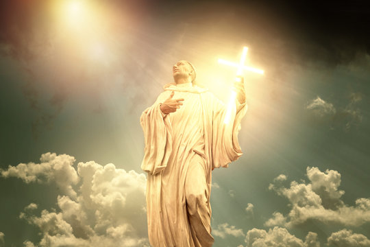 God phantasy holy statue with crucifix and dramatic sky.