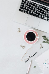 Minimal home office desk workspace with laptop, coffee. notebook, eucalyptus on grey background. Flat lay, top view girlboss concept.