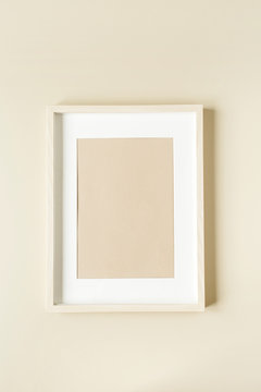 Minimal photo frame on beige wall. Modern interior design concept. Blank copy space mock up.