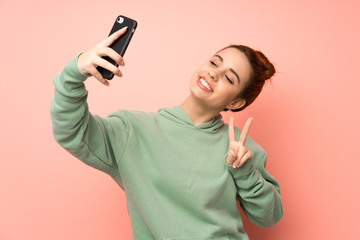 Young redhead woman with sweatshirt making a selfie