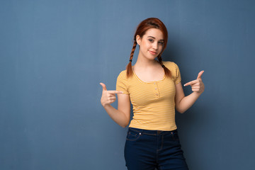 Young redhead woman over blue background proud and self-satisfied in love yourself concept