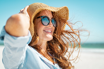 Mature woman with beach hat and sunglasses - Powered by Adobe
