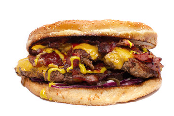 Huge delicious juicy burger with bacon, beef cutlets, fresh lettuce, tomatoes, sauce, onion, cheese and white fresh bun with sesame