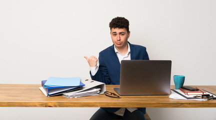 Business man in a office unhappy and pointing to the side