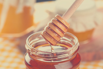 Honey background. Sweet honey in glass jar on wooden background.