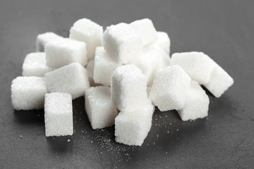 White sugar cubes over black background close up