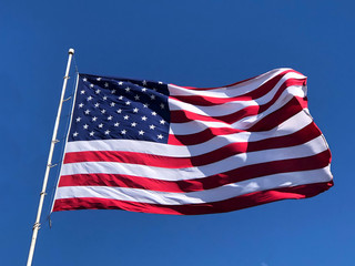American flag waving on blue sky