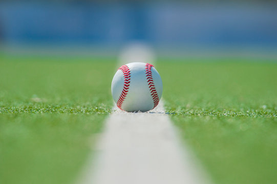 White ball for playing baseball on the grass background