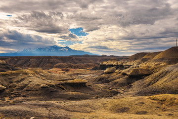 Badlands in Utah with snowy mountains