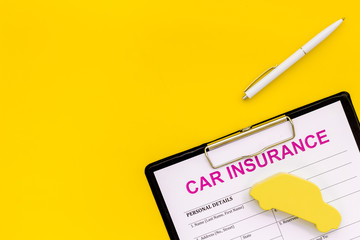 buying new auto concept with insurance form, pen and car toy on yellow background top view space for text